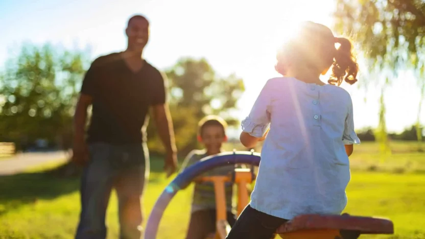 family playing on playground with sun burst