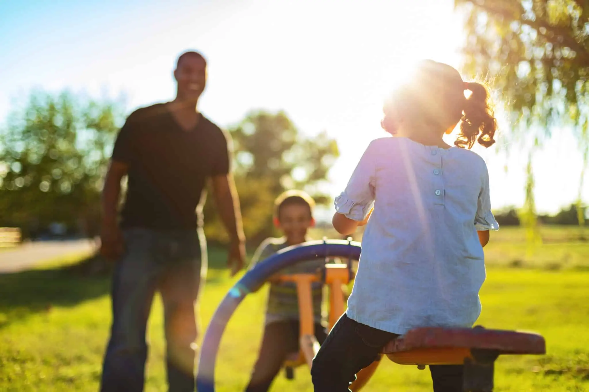 family playing on playground with sun burst